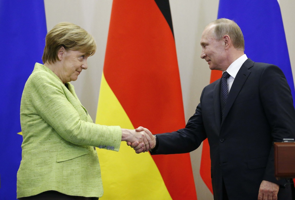 俄罗斯总统普京(右)与德国总理默克尔出席联合新闻发布会时握手